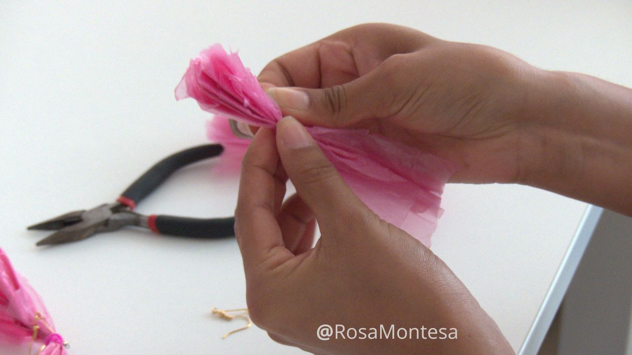 Manos de una niña en el taller de bisutería reciclando bolsas de plástico